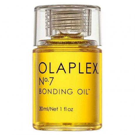 सफेद पृष्ठभूमि पर पीले बालों के तेल की ओलाप्लेक्स नंबर 7 बॉन्डिंग ऑयल की बोतल