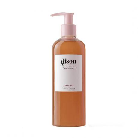 Flacon de spălat pentru păr cu infuzie de miere Gisou de șampon chihlimbar cu etichetă albă și pompă roz pe fundal alb
