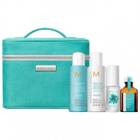 Тюркоазена правоъгълна пътна чанта Moroccanoil Volume Set с продукти за коса пред нея на бял фон