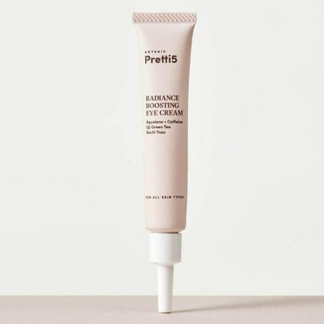 Pretti5 Radiance Boosting Eye Cream w jasnoróżowej tubce z białą szpiczastą czapką na jasnoszarym tle