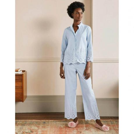 Ensemble de pyjama Boden Broderie modèle portant un pyjama brodé bleu clair dans une pièce neutre avec tapis