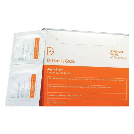 Dr. Dennis Gross Alpha Beta Universal Daily Peel оранжева и бяла кутия и бели сашета от пилинг за лице на бял фон
