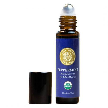 Silk Road Organic Peppermint Essential Oil Roll-On gulungan coklat pada botol minyak dengan label biru dan tutup hitam ke samping dengan latar belakang putih
