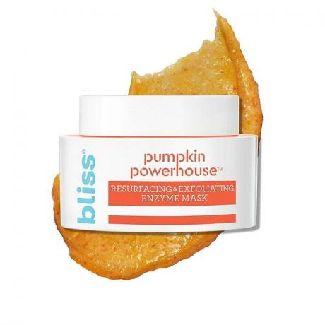 Bliss Pumpkin Powerhouse Face Mask: Vzorník oranžovej masky na tvár za bielou a oranžovou nádobou na bielom pozadí