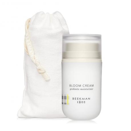 Una bolsa blanca y un frasco de Beekman 1802 Bloom Cream Daily Moisturizer