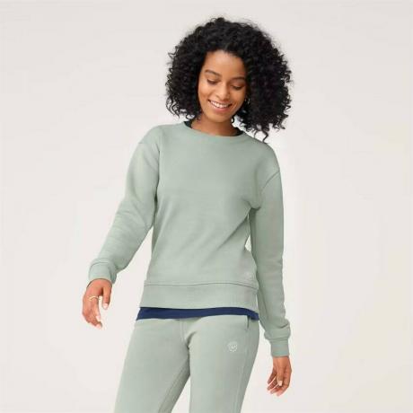 Allbirds R&R Sweatshirt modèle portant un survêtement vert clair sur fond gris clair
