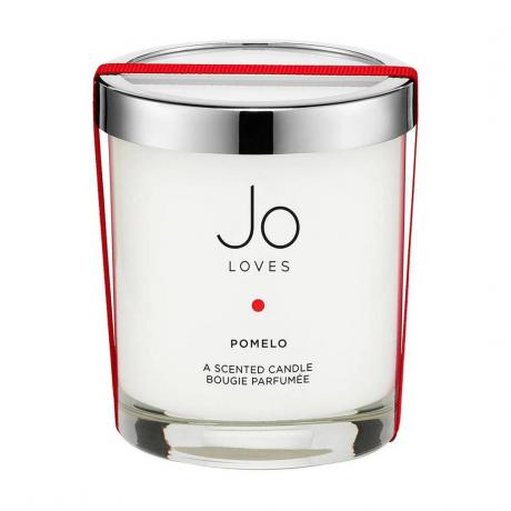 Jo Loves Pomelo شمعة بيضاء بغطاء فضي ملفوفة بشريط أحمر على خلفية بيضاء