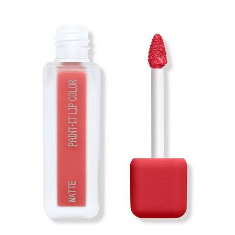 Een doorzichtige rechthoekige tube met bijpassende doe-voet applicator van de About-Face Paint-It Matte Lip Colour in primaire rode tint Serrated Bite op een blanco achtergrond