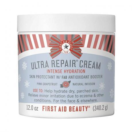 Un pot de la crème ultra réparatrice First Aid Beauty au pamplemousse rose sur fond blanc