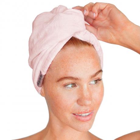 Modello di asciugamano per capelli in microfibra Kitsch che indossa un asciugamano per capelli rosa su sfondo bianco
