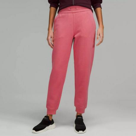 عارضة أزياء Lululemon Scuba High-Rise Jogger ترتدي بنطالًا ورديًا على خلفية رمادية