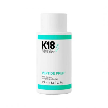 K18 Peptide Prep Clarifying Detox Shampoo balta pudele ar ūdens svītrām uz balta fona
