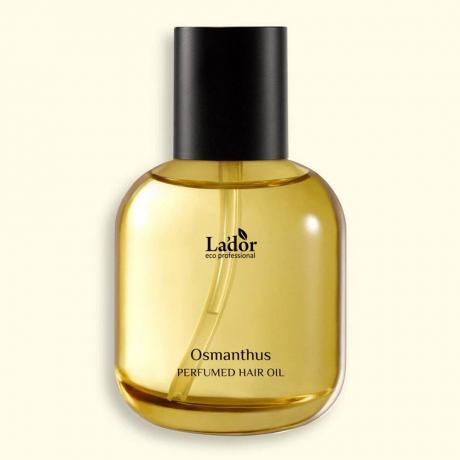 Botol bening Minyak Rambut La'Dor Perfumed dengan tutup hitam dengan latar belakang kuning