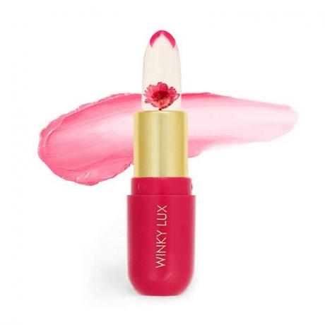 Tabung lipstik merah muda dari Winky Lux Flower Balm dengan latar belakang putih
