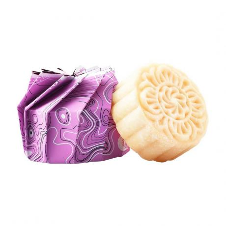 شريط شامبو الشعر من Viori Hair Shampoo Bar مستدير باللون البيج مع تصميم زهور منحوتة وعبوة ورقية أرجوانية على خلفية بيضاء