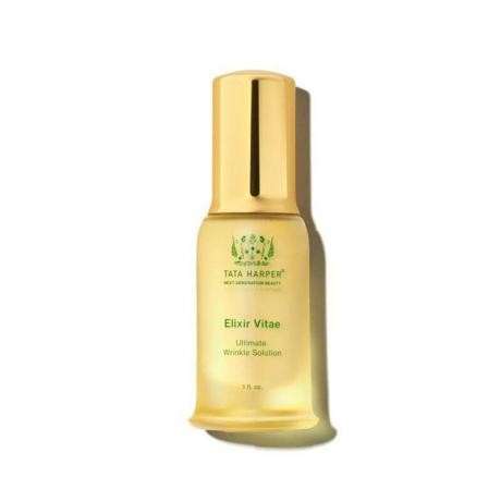 Tata Harper Elixir Vitae: მინის ბოთლი ოქროს თავსახურით და მწვანე ტექსტით თეთრ ფონზე