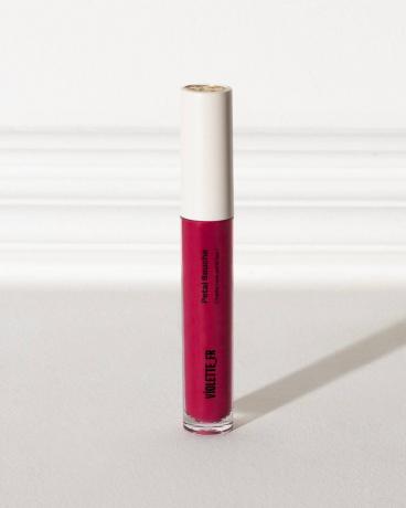 tubo de color de labios rosa con tapa blanca sobre fondo blanco