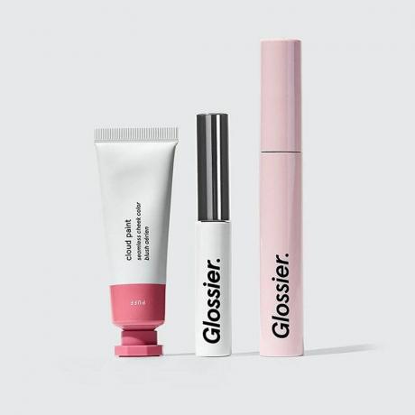 The Glossier The Makeup Set tubo de tinta em nuvem, sobrancelha de menino e rímel rosa em um fundo cinza