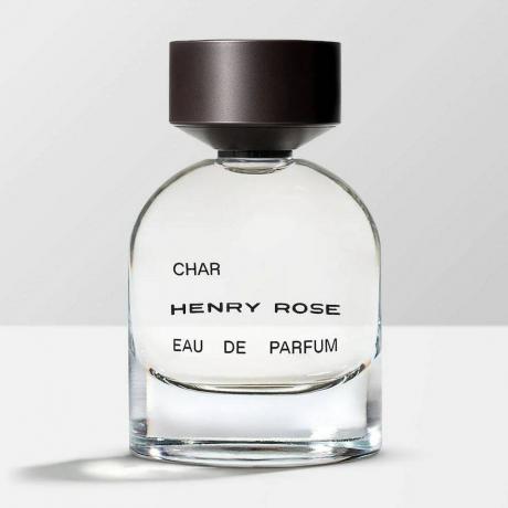 Henry Rose Char Eau de Parfum Michelle Pfeiffer zaobljena prozorna steklenička s črnim pokrovčkom na beli površini s sivim ozadjem