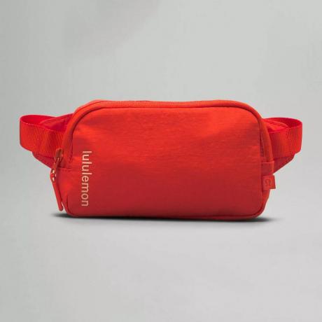 „Lululemon Mini Belt Bag“ oranžinė „fanny“ pakuotė pilkame fone