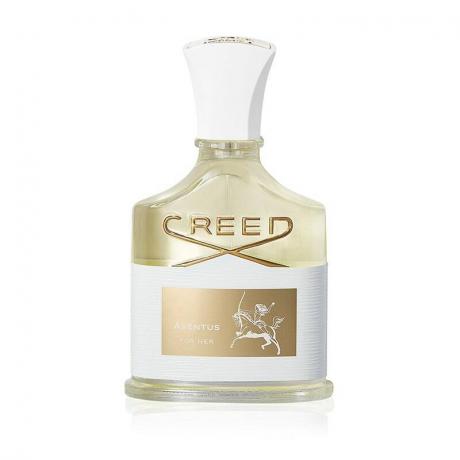 Skleněný parfémový flakon s bílými a zlatými detaily naplněný parfémovanou vodou Creed Aventus na bílém pozadí