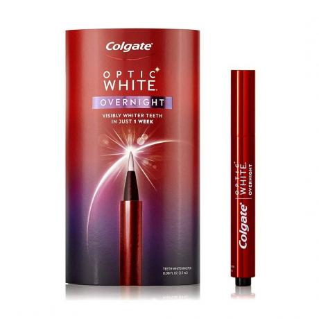 Aplikator pena gigi merah dengan teks putih yang bertuliskan " Colgate Optic White Overnight Teeth Whitening Pen" di sebelah kotak kemasan merah dan putih yang serasi, semuanya dengan latar belakang putih.
