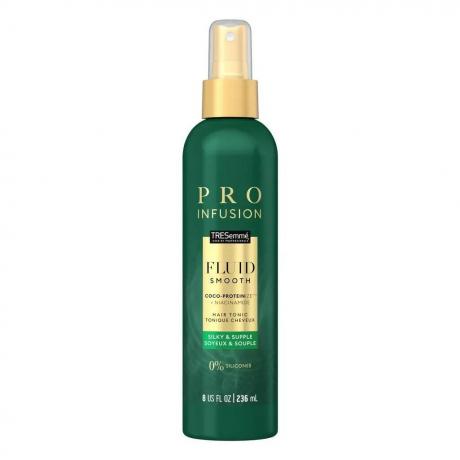 Tresemmé Pro Infusion Fluid Smooth Hair Tonic flacon verde cu etichetă aurie și capac de pulverizare auriu pe fundal alb