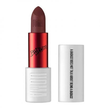 Uoma Beauty Badass Icon Matte Lipstick tubo blanco y rojo de lápiz labial burdeos oscuro con tapa a un lado sobre fondo blanco