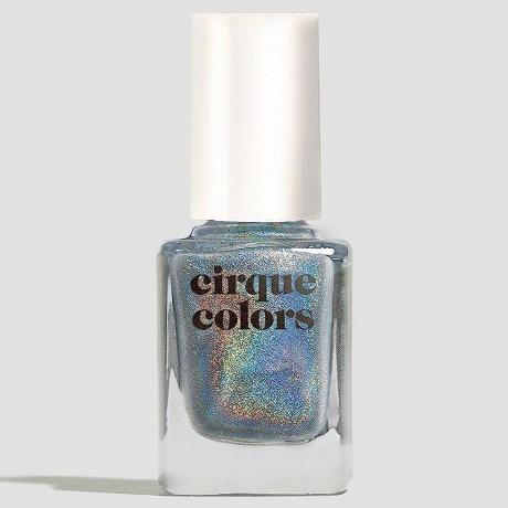 Голографічний лак для нігтів Cirque Colours у флаконі сріблястого райдужного лаку для нігтів We Trippy з білою кришкою на сірому фоні