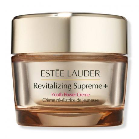 Zlat kozarec z ujemajočim se pokrovčkom Estée Lauder Revitalizing Supreme+ Youth Power Crème na belem ozadju