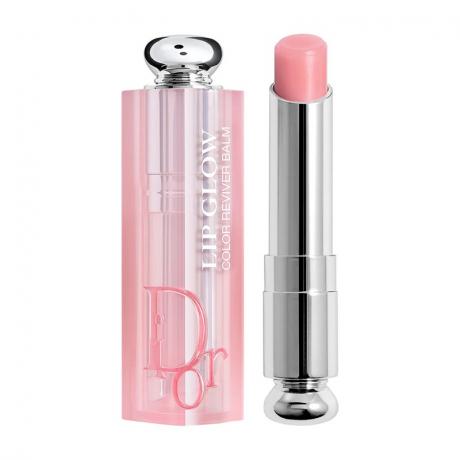 Dior Addict Lip Glow Balm tabung perak dari lip balm merah muda dan topi merah muda dengan latar belakang putih