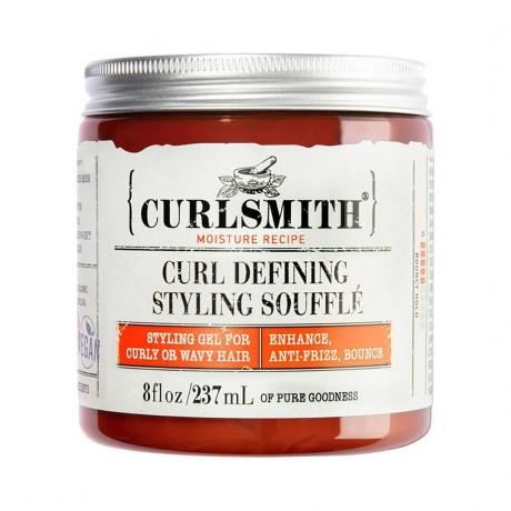 Curlsmith Curl Defining Styling Soufflé orange burk med beige etikett och silver lock på vit bakgrund