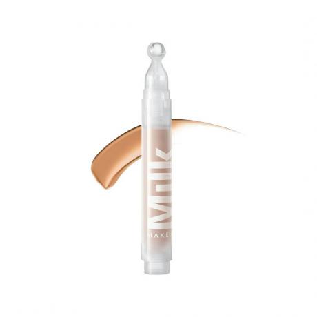 Milk Makeup Sunshine Under Eye Tint + Brighten tubo transparente de corrector con muestra sobre fondo blanco