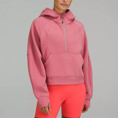 Lululemon Scuba Oversized Half-Zip hoodie model, oblečen v roza pulover s pol zadrgo na sivem ozadju