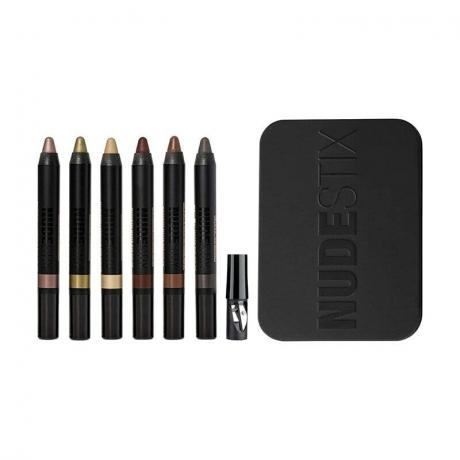 Nudestix Nude Earth Eye Pencil Set: Sechs cremebasierte Lidschattenstifte neben einer schwarzen Tragetasche auf weißem Hintergrund
