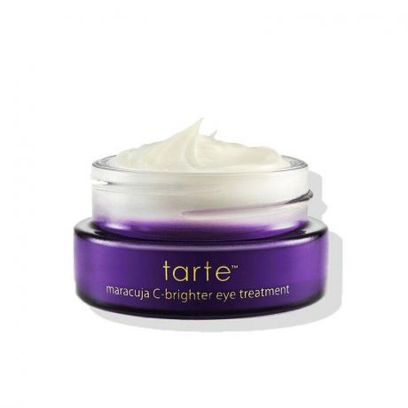 Un pot violet ouvert rempli de la crème blanche Tarte Maracuja C-Brighter Eye Treatment sur fond blanc