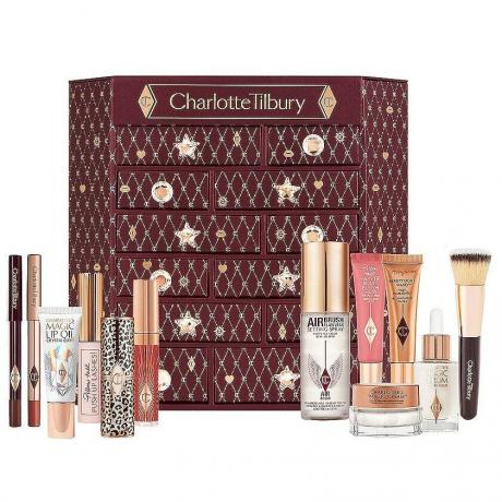 Charlotte Tilbury Caixa marrom Lucky Chest Of Beauty Secrets de Charlotte com produtos Charlotte Tilbury na frente em fundo branco